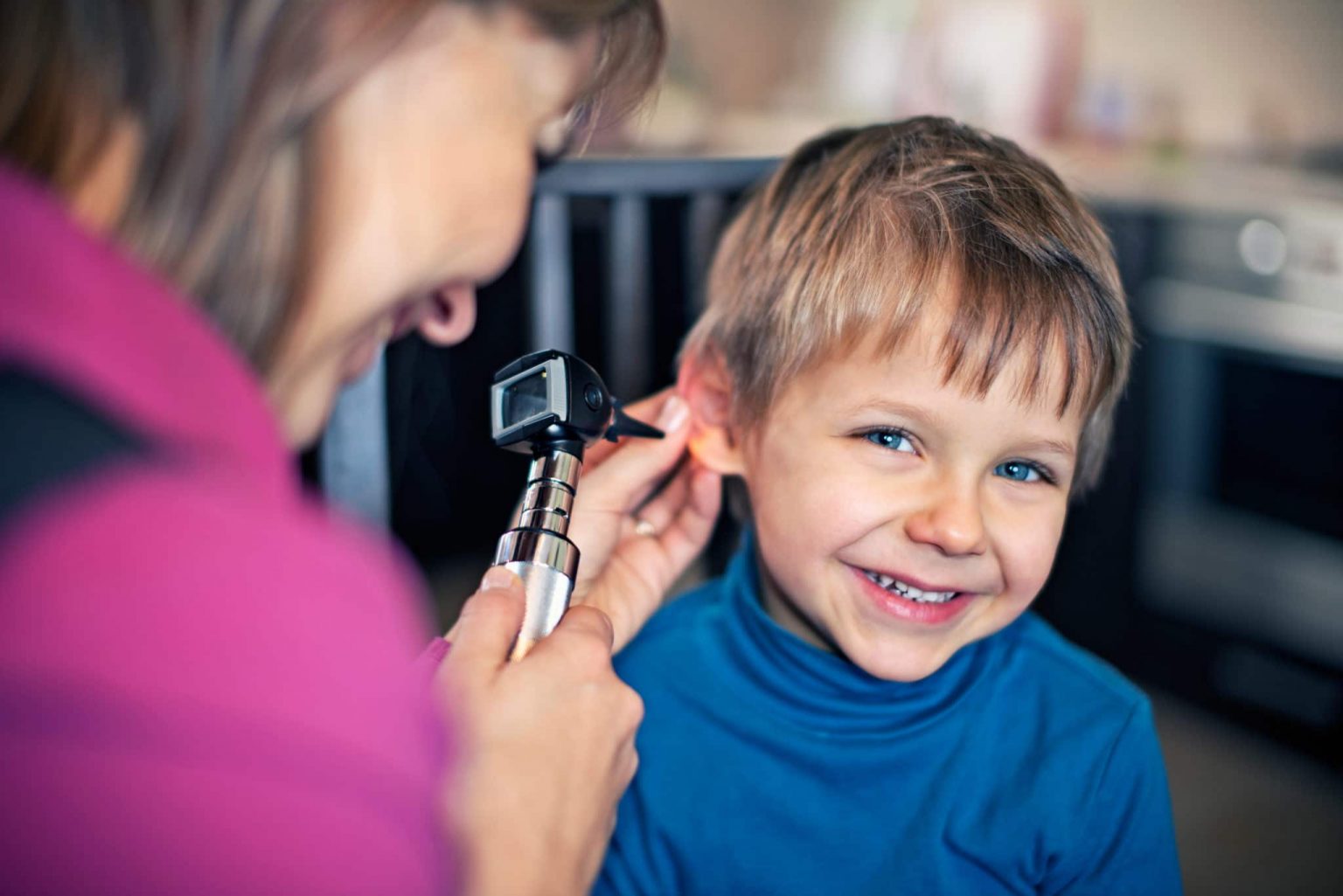 ENT checks child patients ears to determine ear tube effectiveness