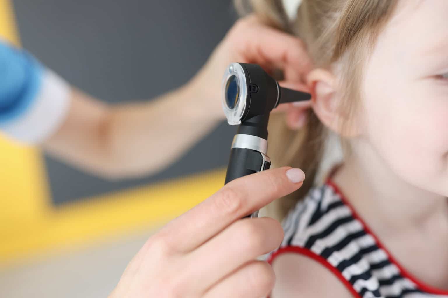Doctor examining the ears of a young girl.