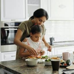 Mother and daughter preparing food in the kitchen.
