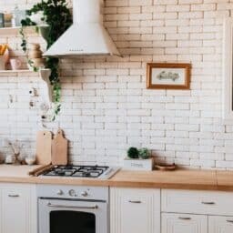 A modern looking kitchen with white brick background.